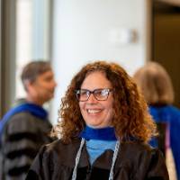 A woman faculty member smiles